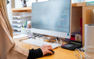 Orthodontic office coordinator reviewing summer patient scheduling to prevent appointment errors in a busy clinic.